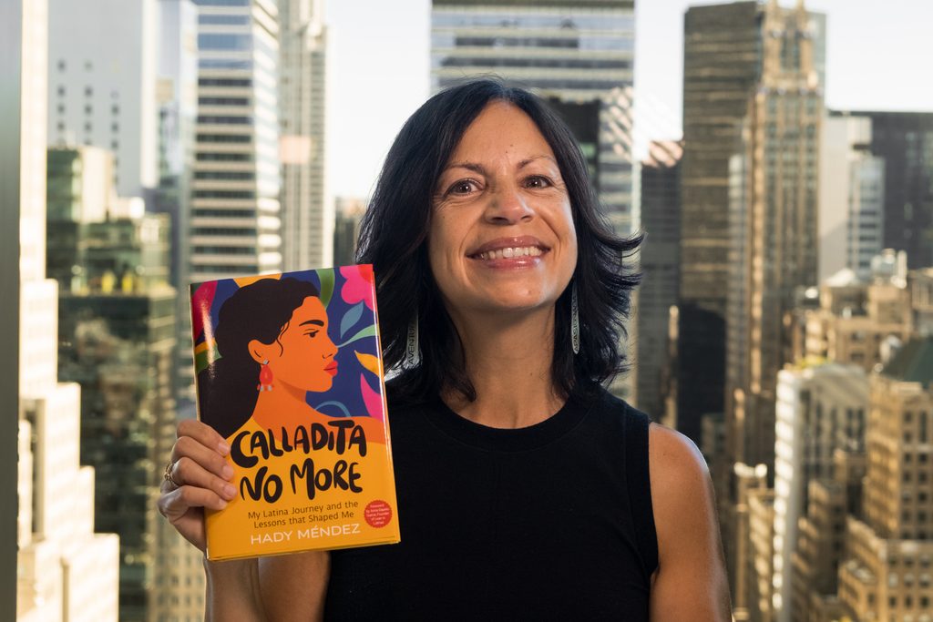 Hay Méndez holding her book, Calladita No More.